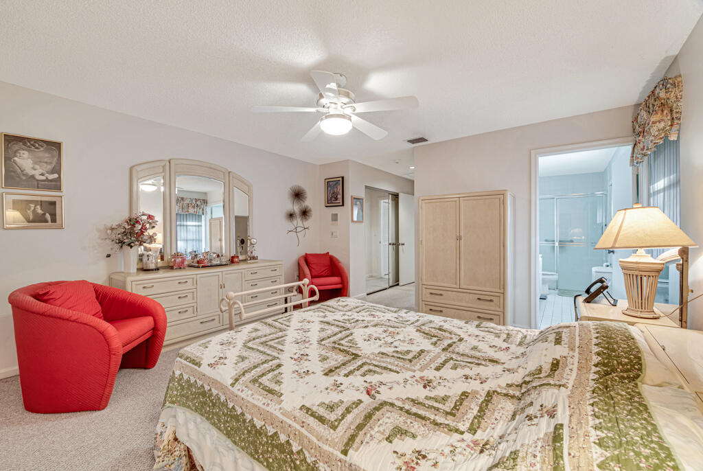 9976 Seacrest Circle, Unit A Boynton Beach, FL 33437 - Photo 18 of 48 a bedroom with a bed and ceiling fan