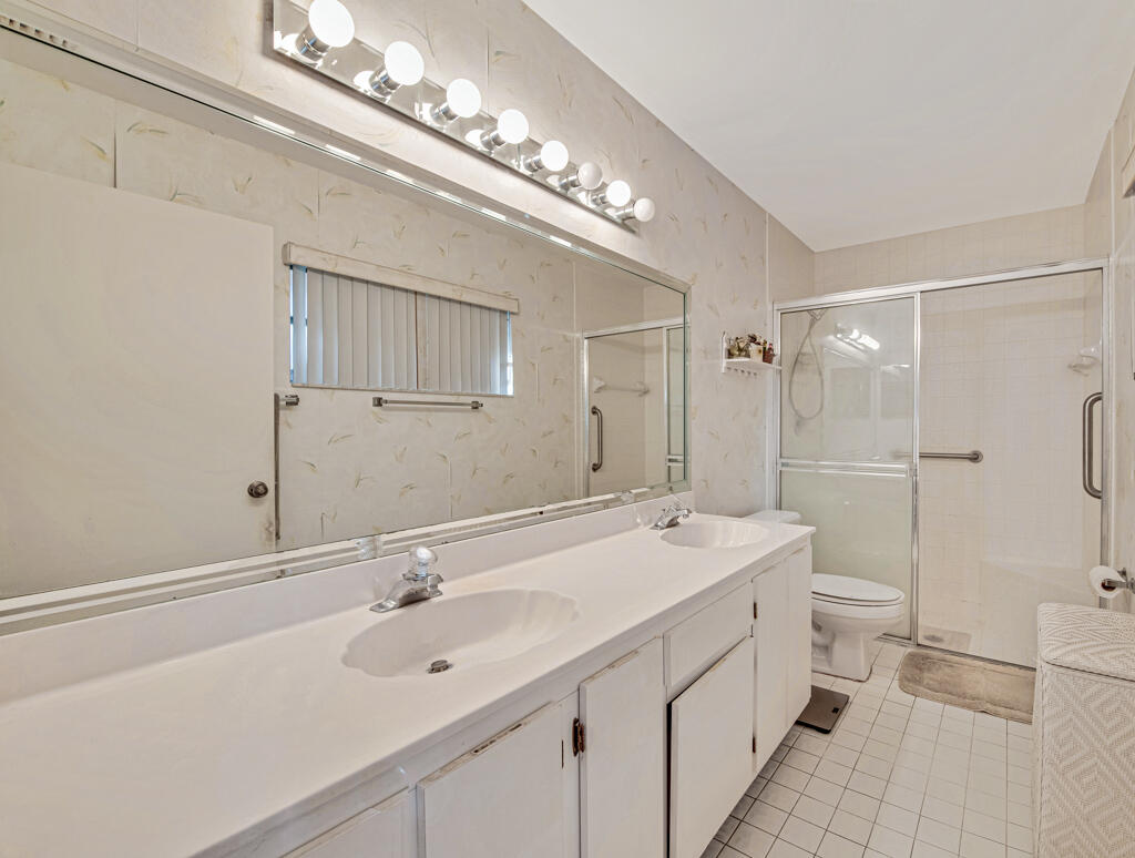 9976 Seacrest Circle, Unit A Boynton Beach, FL 33437 - Photo 20 of 48 a spacious bathroom with a double vanity sink mirror and toilet