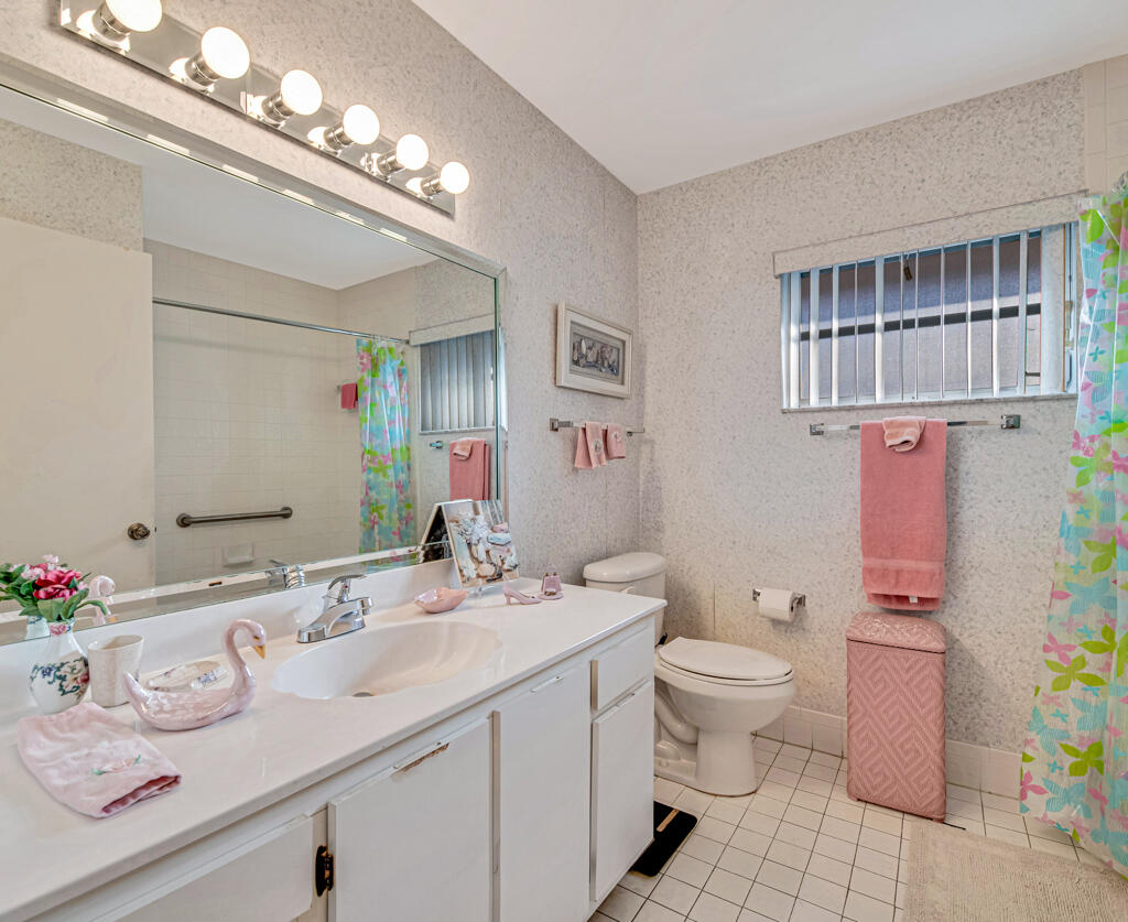 9976 Seacrest Circle, Unit A Boynton Beach, FL 33437 - Photo 27 of 48 a bathroom with a sink a toilet and a mirror