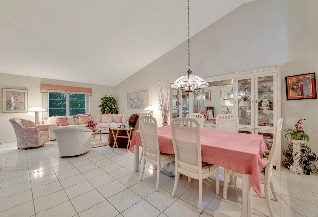 9976 Seacrest Circle, Unit A Boynton Beach, FL 33437 - Photo 3 of 48 a dining room with furniture a chandelier and window
