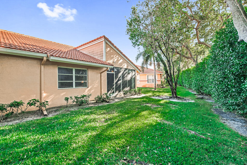 9976 Seacrest Circle, Unit A Boynton Beach, FL 33437 - Photo 38 of 48 a backyard of a house with table and chairs