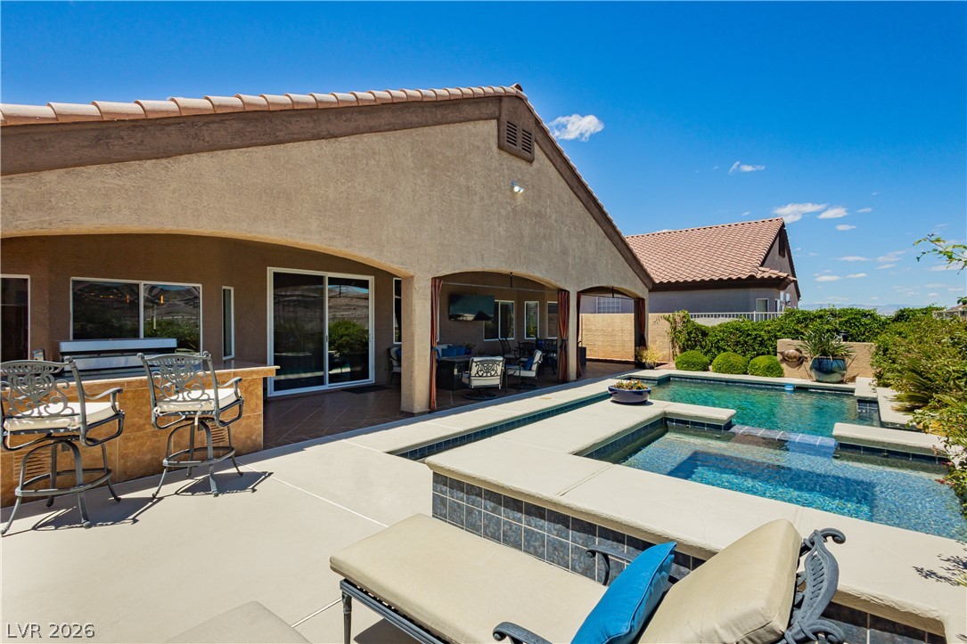 2256 Dogwood Ranch Avenue Henderson, NV 89052 - Photo 49 of 51 A spacious backyard patio with an in-ground pool and an outdoor kitchen for ultimate relaxation.