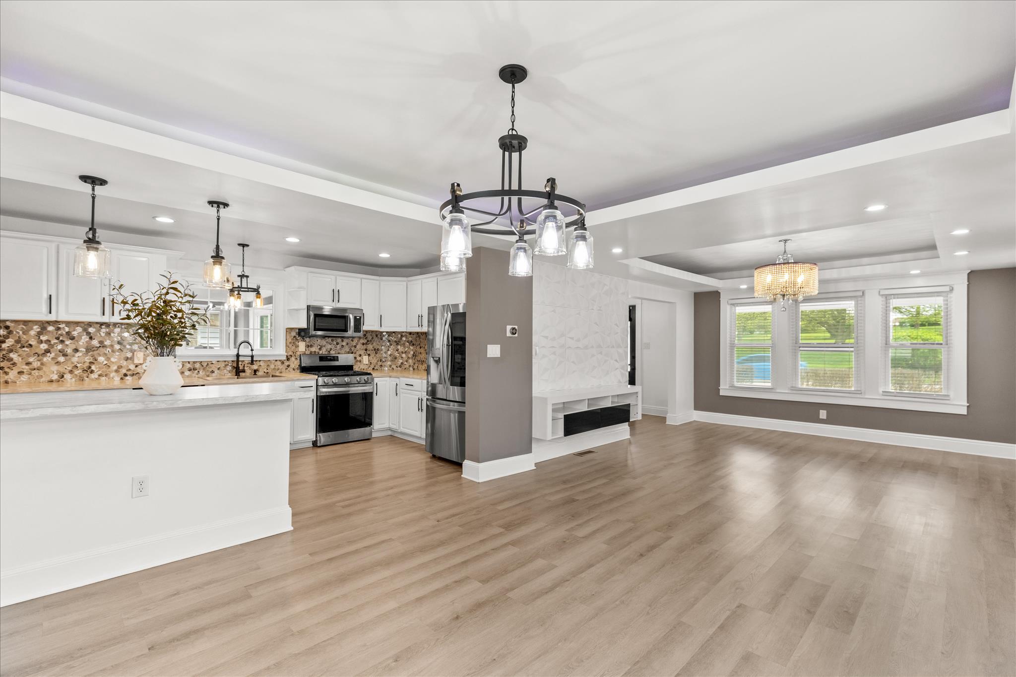 310 Hanover Road York, PA 17408 - Photo 12 of 56 a view of a kitchen with granite countertop wooden floor stainless steel appliances and a chandelier