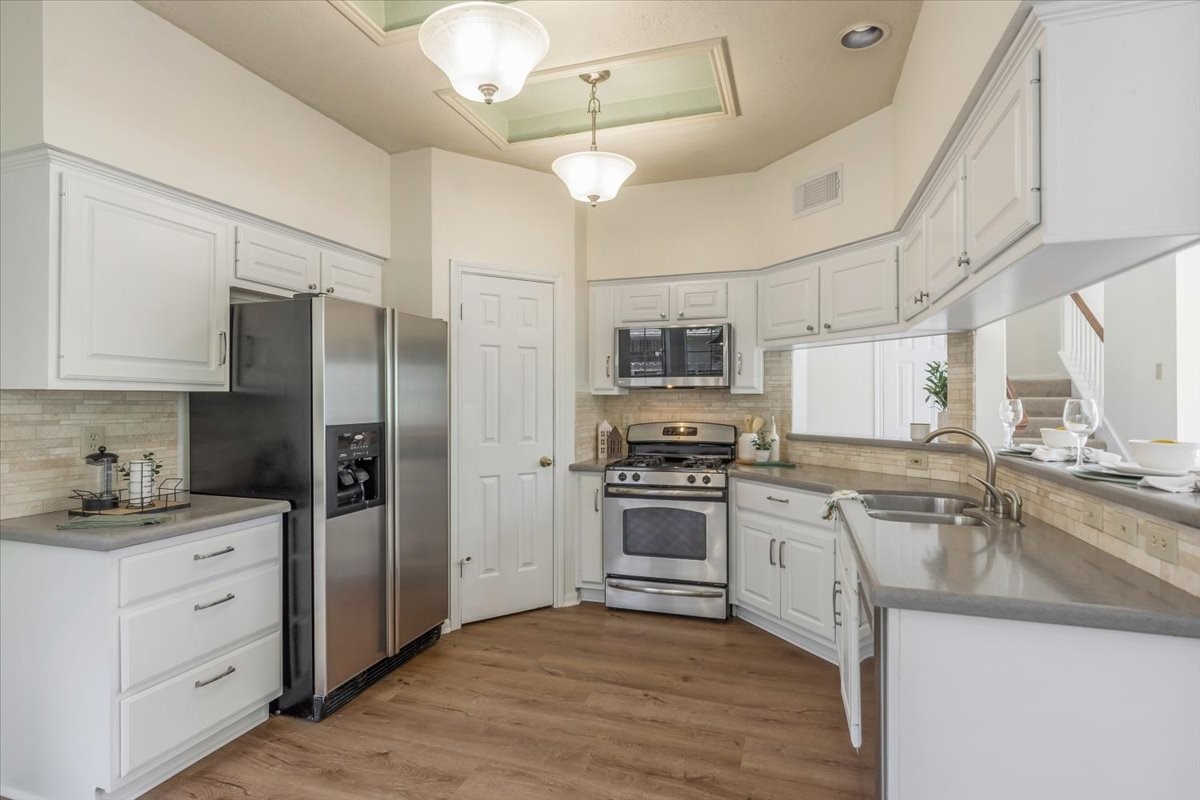 1730 Mabry Mill Road Houston, TX 77062 - Photo 9 of 47 Bright kitchen with white cabinetry, stainless-steel appliances, and generous workspace. Refrigerator is included.