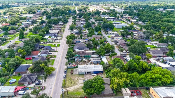 an aerial view of residential houses with outdoor space and trees all around
