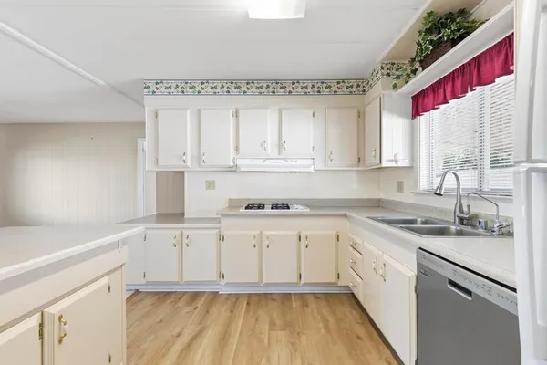 a kitchen with granite countertop white cabinets and white appliances