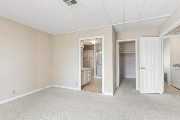 an empty room with closet and a bathroom
