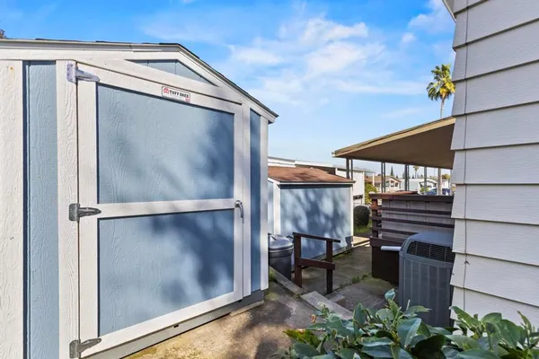 a front view of a house with garden and trees