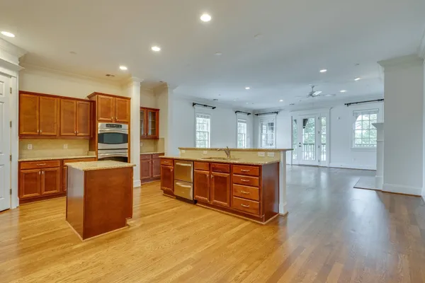 a large kitchen with stainless steel appliances wooden floors and large counter space