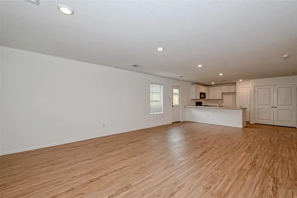 a view of empty room with wooden floor and window