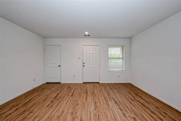 a view of a room with wooden floor and window