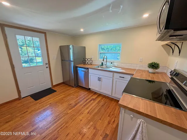 a kitchen with granite countertop a sink cabinets and wooden floor