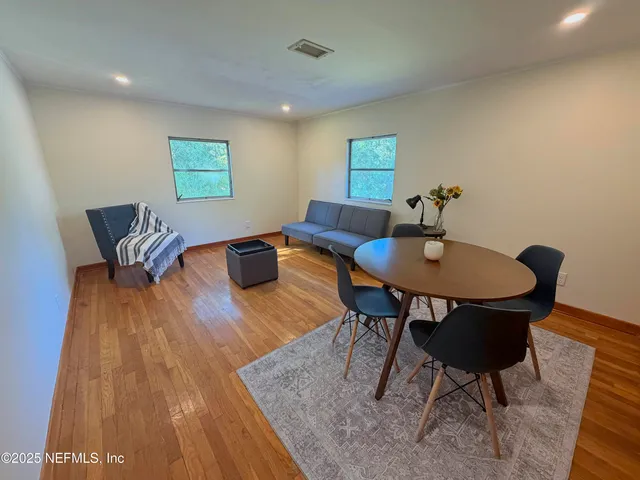 a living room with dining room and wooden floor