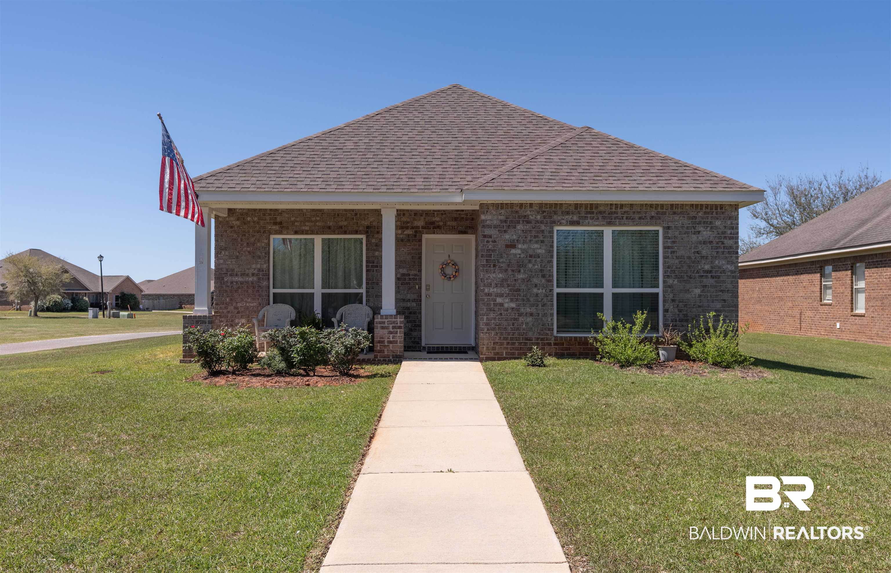 23809 Devonfield Lane Daphne, AL 36526 - Photo 1 of 29 Bungalow-style home with brick siding, roof with shingles, and a front lawn