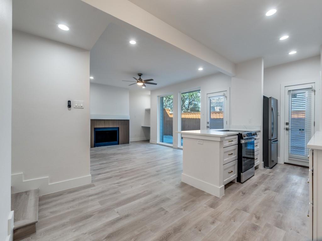 5755 Phoenix Drive, Unit A Dallas, TX 75231 - Photo 11 of 28 an empty room with kitchen and fireplace
