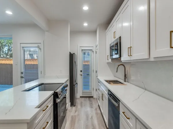 a kitchen with stainless steel appliances granite countertop a sink stove and refrigerator