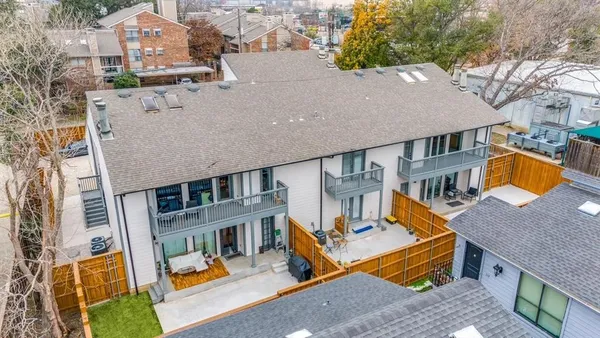 an aerial view of multiple houses with a yard