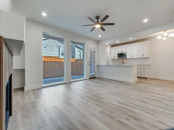 a view of a kitchen with a sink dishwasher a refrigerator and wooden floor