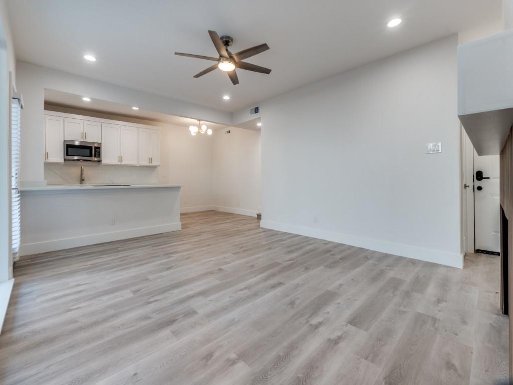 5755 Phoenix Drive, Unit A Dallas, TX 75231 - Photo 7 of 28 an empty room with wooden floor and a ceiling fan