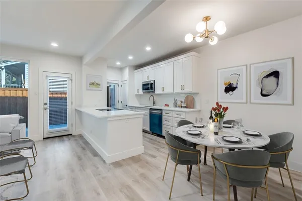 a kitchen with a dining table chairs stainless steel appliances and cabinets