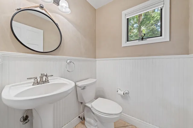 a bathroom with a toilet a sink and a mirror