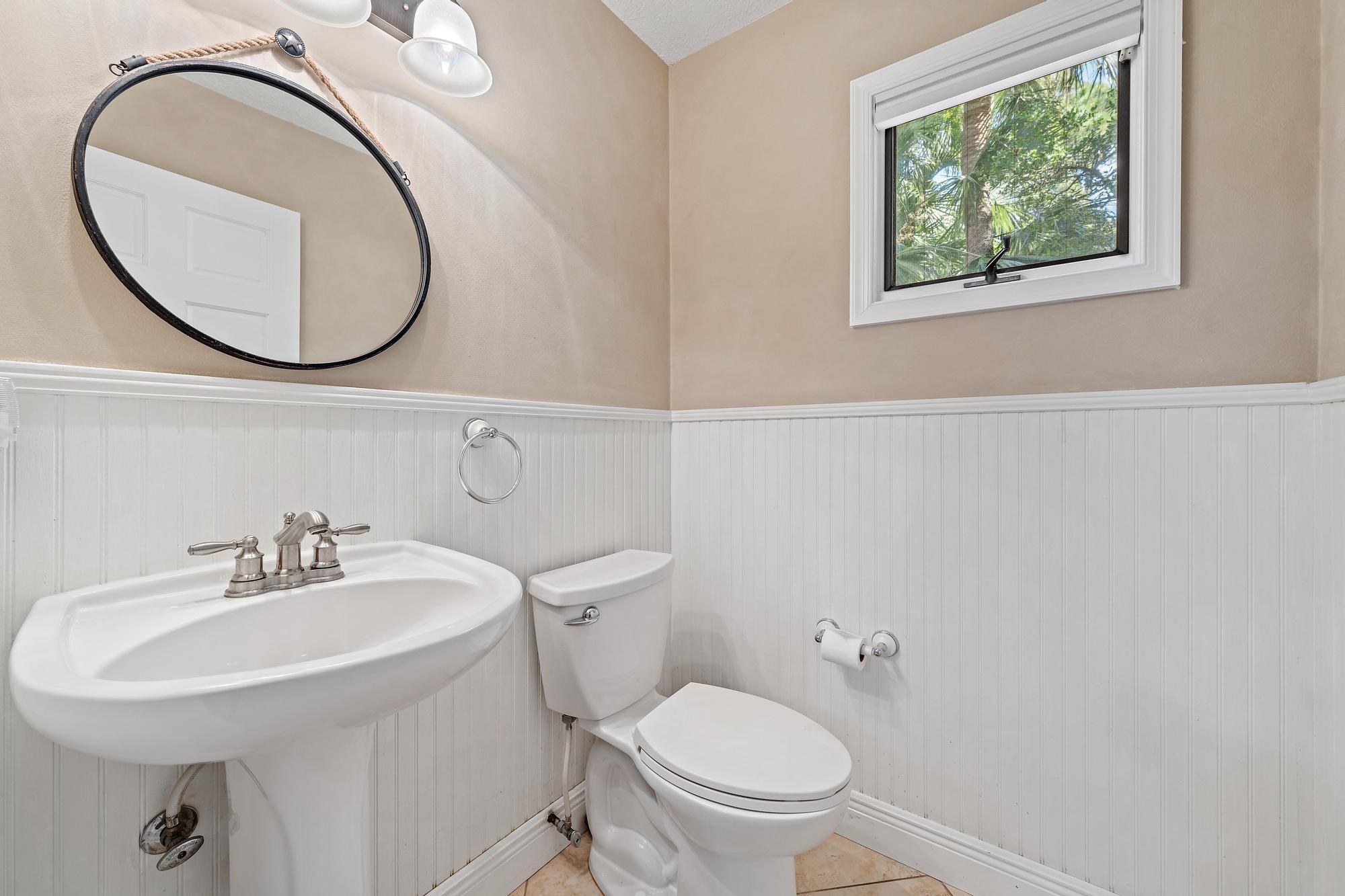19150 Southeast Jupiter Road Jupiter, FL 33458 - Photo 13 of 43 a bathroom with a toilet a sink and a mirror
