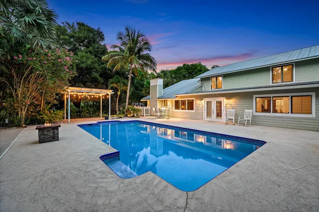 a view of a house with swimming pool and sitting area