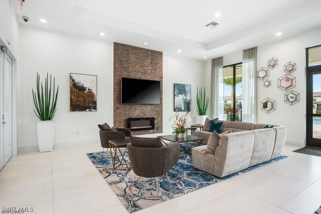 7464 Rockefeller Drive Naples, FL 34119 - Photo 16 of 22 a living room with furniture a flat screen tv and a fireplace
