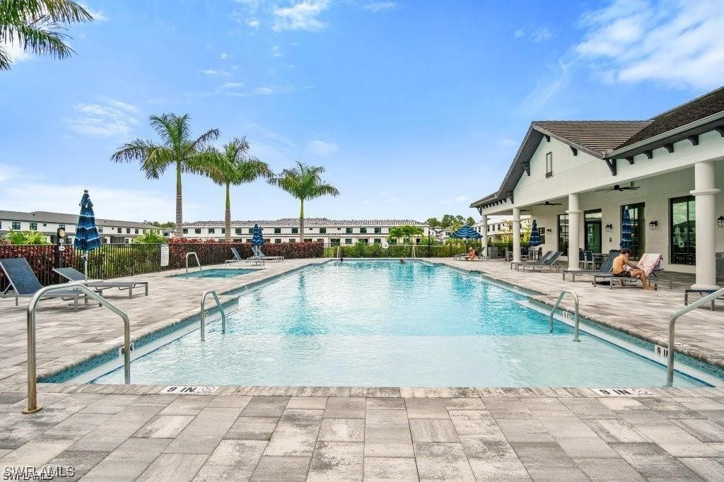 7464 Rockefeller Drive Naples, FL 34119 - Photo 19 of 22 a view of a swimming pool with a lounge chair and palm trees