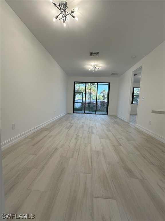 7464 Rockefeller Drive Naples, FL 34119 - Photo 3 of 22 an empty room with wooden floor and windows
