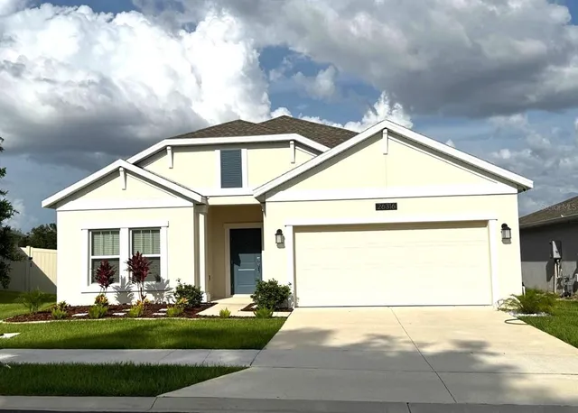 a front view of a house with a yard and garage