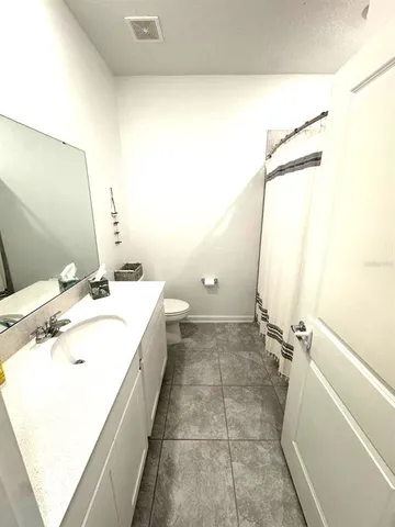 a bathroom with a sink and mirror with bathtub