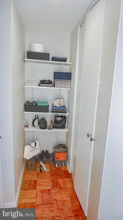 a room with white cabinets and wooden floor