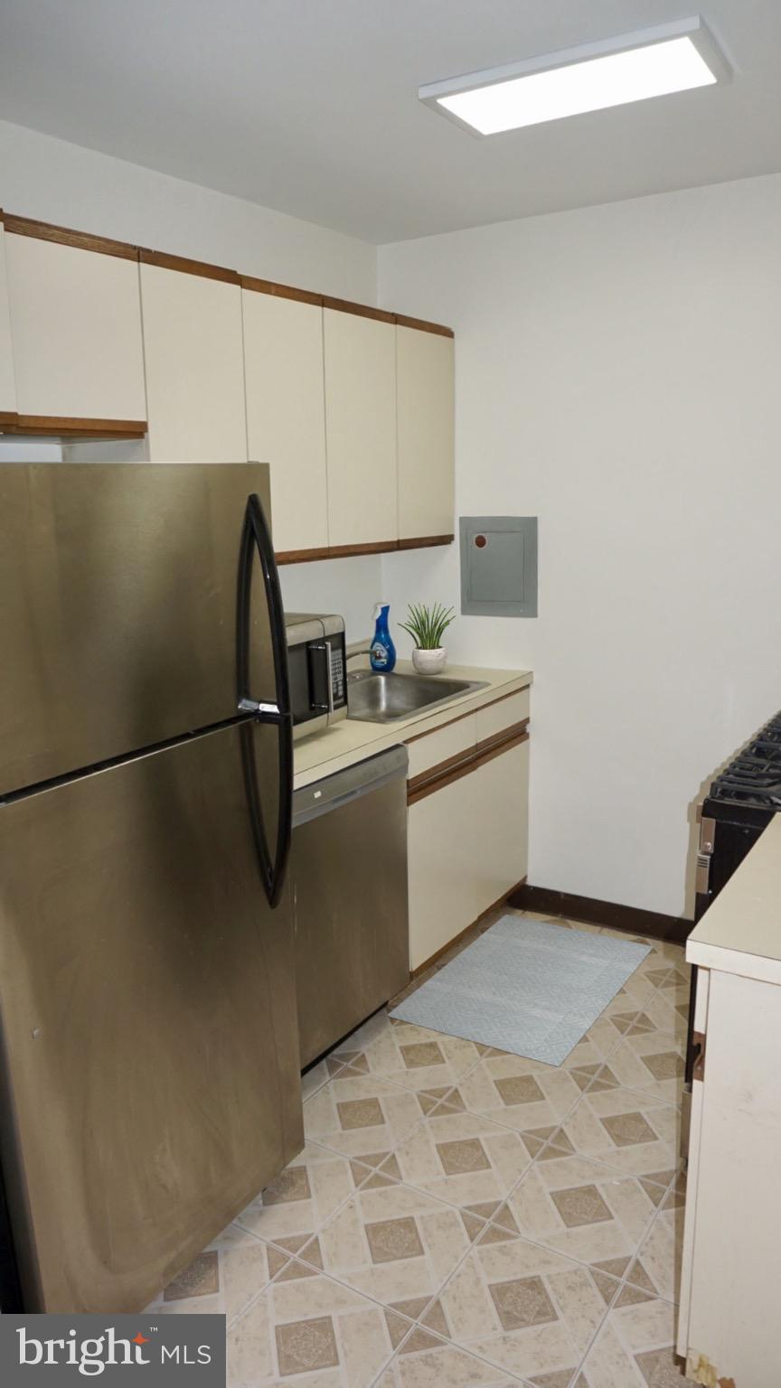 2030 F Street Northwest, Unit 508 Washington, DC 20006 - Photo 6 of 12 a kitchen with stainless steel appliances granite countertop a refrigerator sink and cabinets