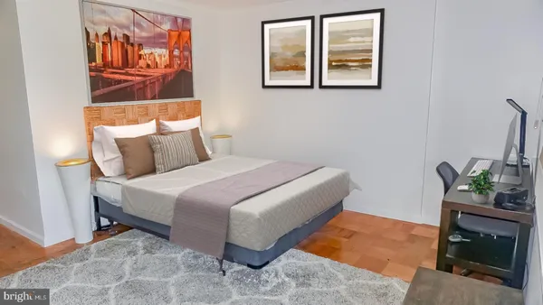 a bedroom with a bed and painting on the wall