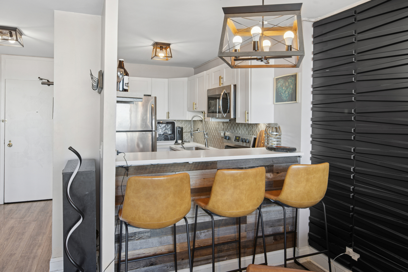 5455 North Sheridan Road, Unit 2805 Chicago, IL 60640 - Photo 10 of 20 a kitchen with stainless steel appliances granite countertop a table chairs and a refrigerator