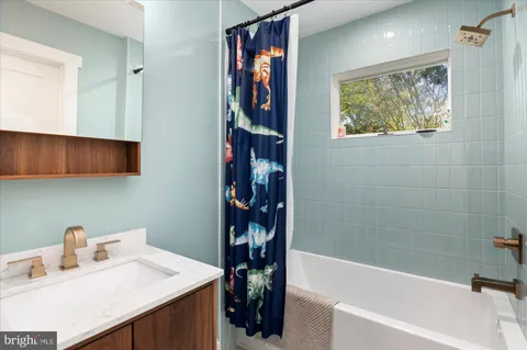 a bathroom with a bathtub sink and a window