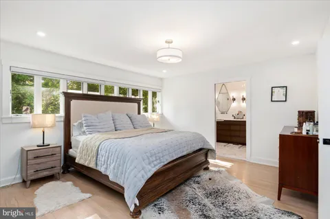 a bedroom with a bed and a dresser with rug