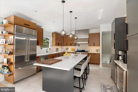 a kitchen with stainless steel appliances granite countertop a refrigerator a sink a stove and a center island