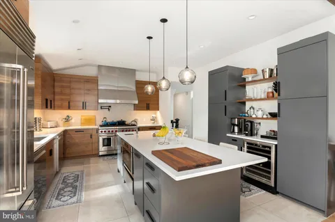 a kitchen that has a lot of cabinets a sink and a wooden floor