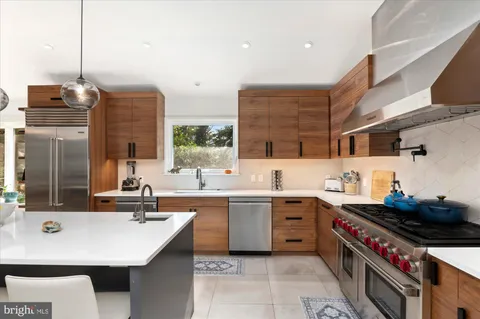 a kitchen with a sink a stove and chairs