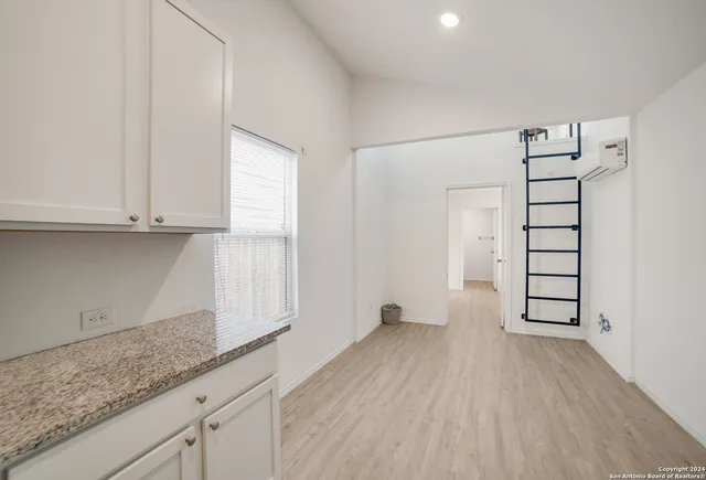 a view of a kitchen with wooden floor and cabinets
