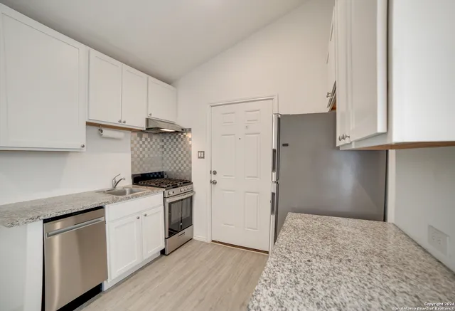 a kitchen with a stove a sink and a refrigerator