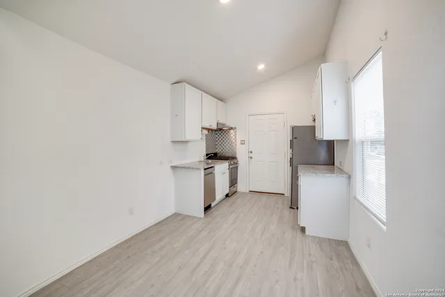 a kitchen with a refrigerator and a stove top oven