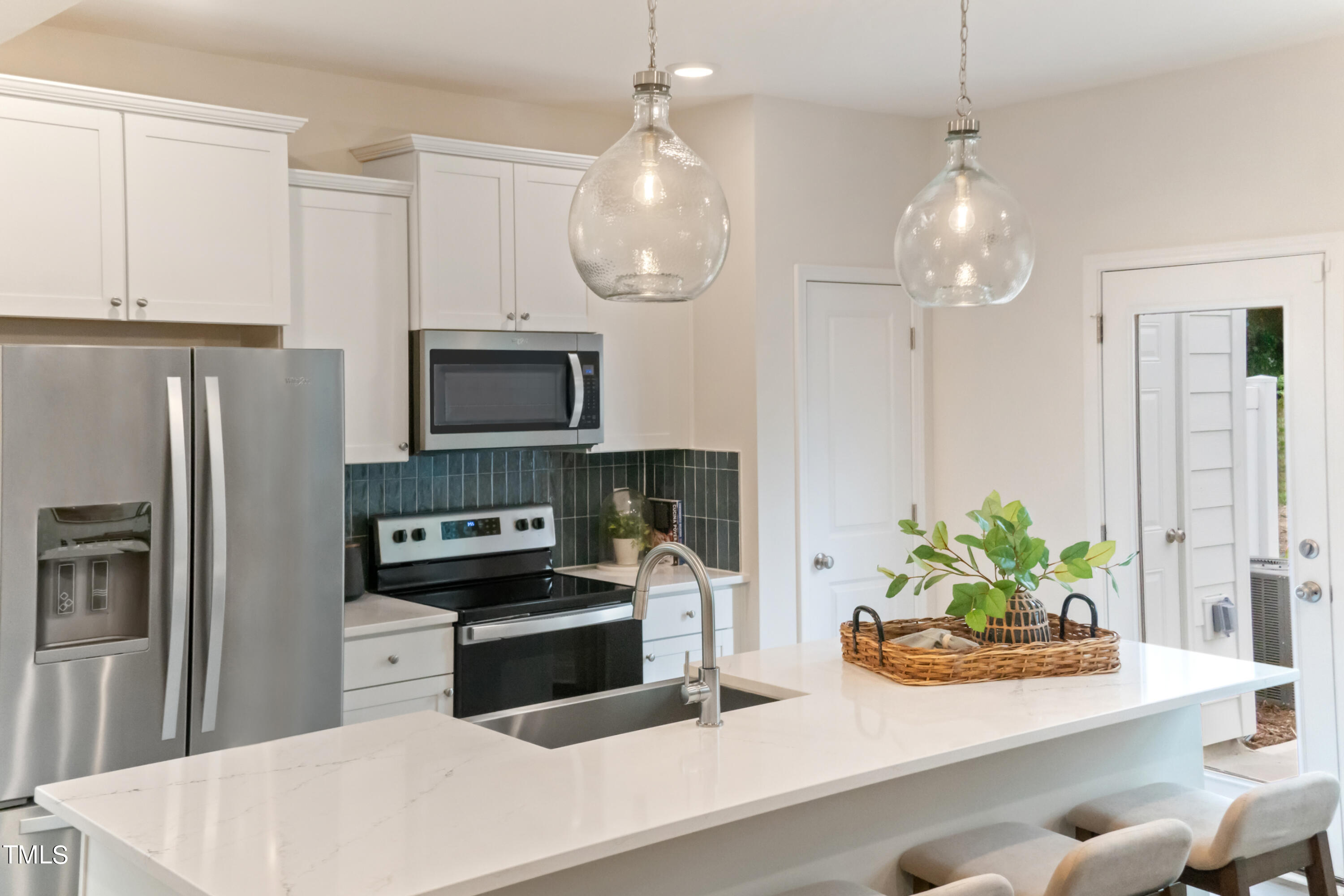 4909 Caddis Bend Raleigh, NC 27604 - Photo 16 of 30 a kitchen with stainless steel appliances granite countertop a stove a refrigerator and a white cabinets