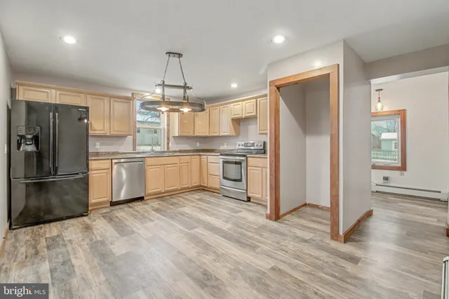 a kitchen with granite countertop a refrigerator and a sink