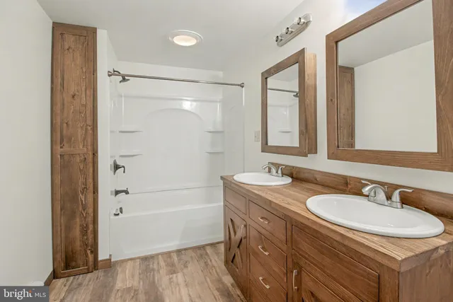 a bathroom with a granite countertop sink a mirror and a shower