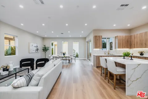 a large kitchen with kitchen island lots of counter space a sink a window and chairs