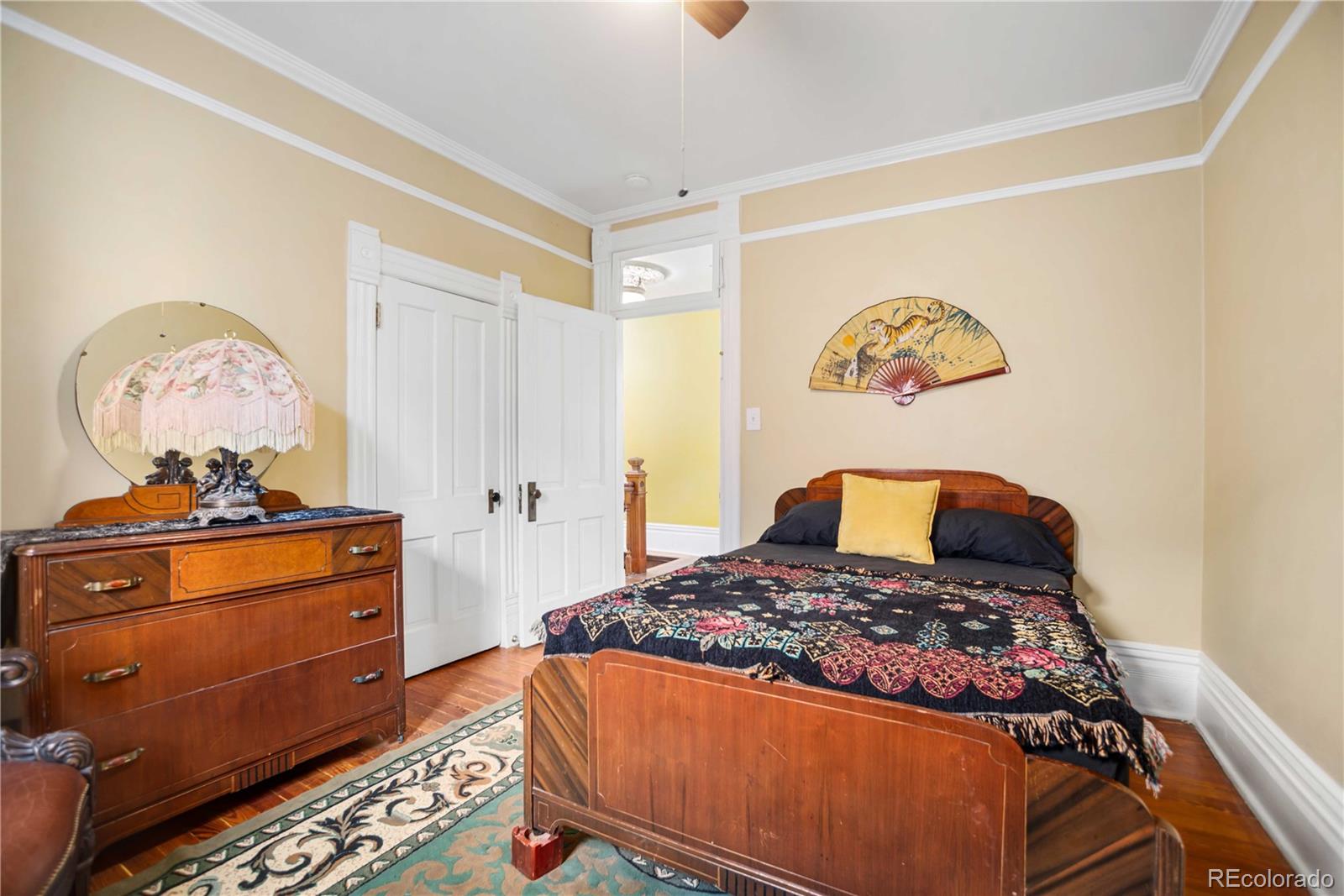 2623 Stout Street Denver, CO 80205 - Photo 22 of 39 a bedroom with a bed and wooden floor