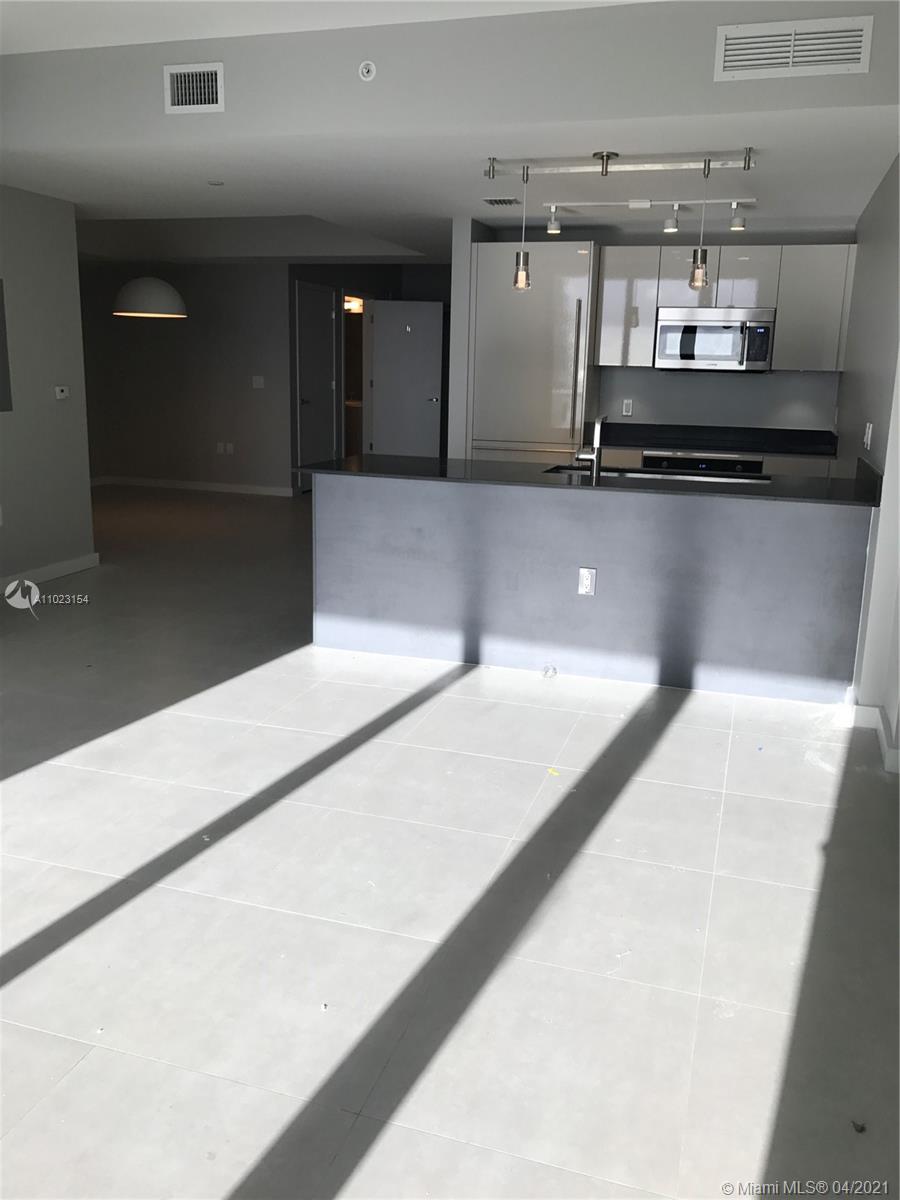 1010 Brickell Avenue, Unit 3204 Miami, FL 33131 - Photo 25 of 32 a kitchen with kitchen island a sink and stove